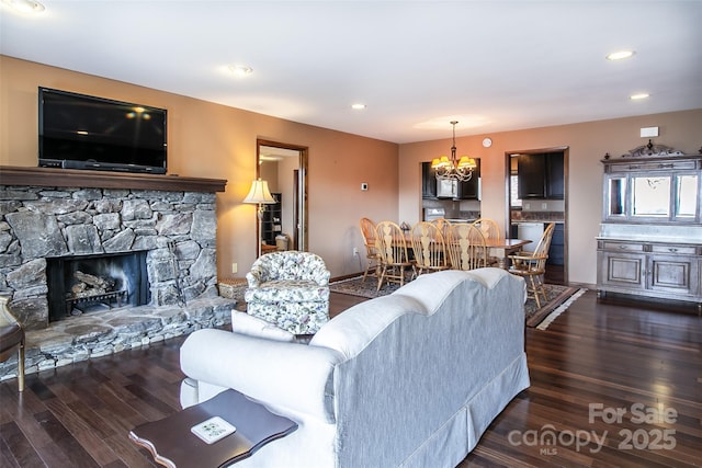 living room with recessed lighting, a fireplace, and dark wood finished floors