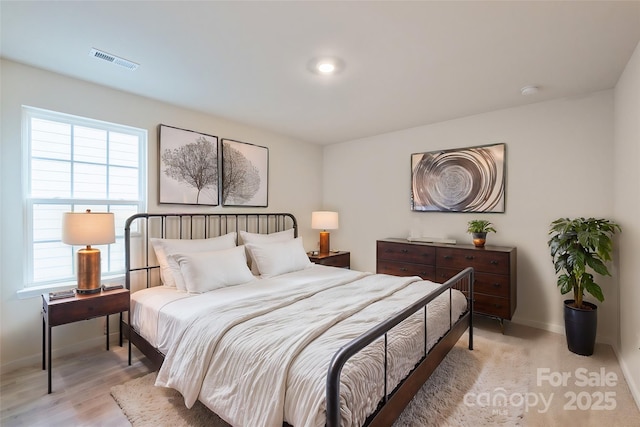 bedroom featuring visible vents, light wood finished floors, and baseboards