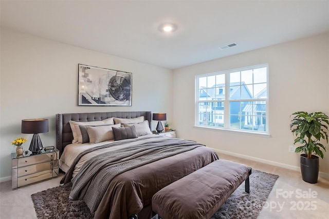 bedroom featuring visible vents, baseboards, and light colored carpet