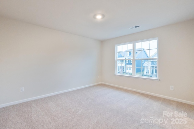 unfurnished room featuring baseboards and light colored carpet