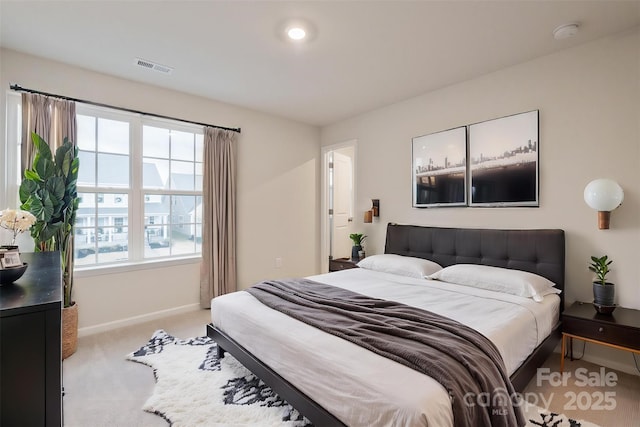 bedroom with light carpet, visible vents, and baseboards