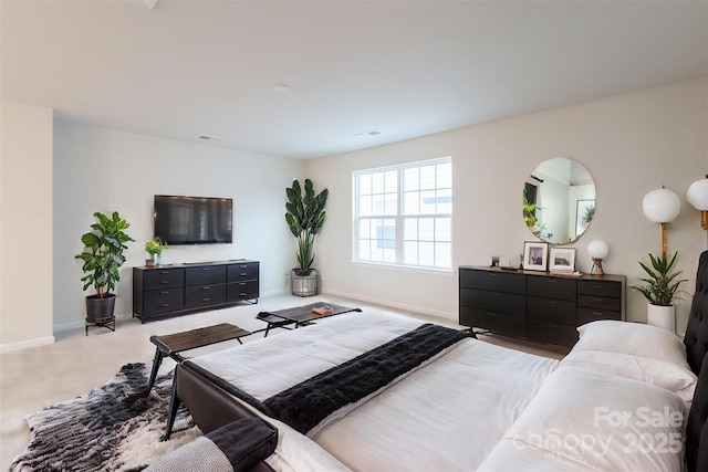 bedroom featuring light colored carpet and baseboards