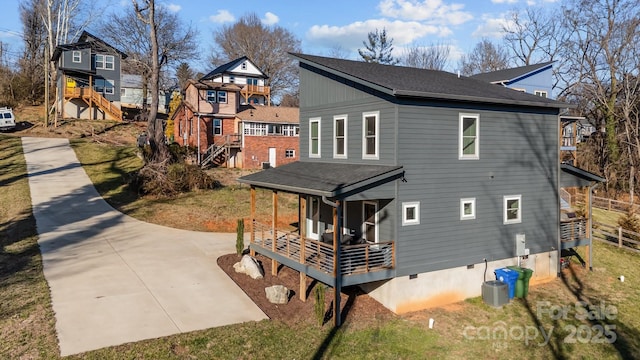 exterior space featuring stairs, covered porch, roof with shingles, and central AC unit