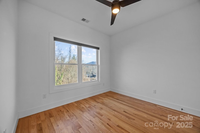 unfurnished room featuring light wood-style floors, visible vents, ceiling fan, and baseboards