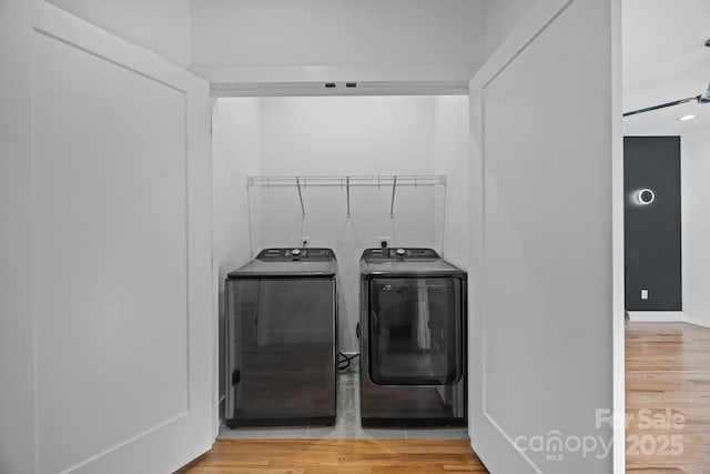 laundry room featuring washer and dryer, laundry area, and wood finished floors