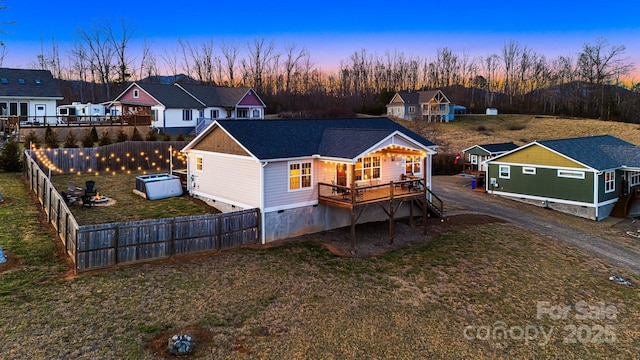 rear view of property with a deck, a fenced backyard, dirt driveway, a yard, and crawl space