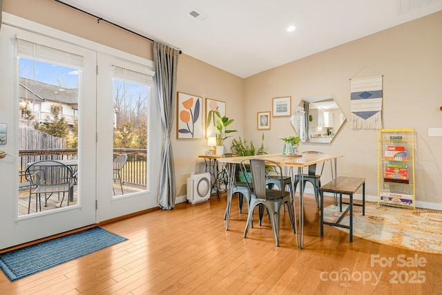 dining area featuring visible vents, baseboards, and wood finished floors