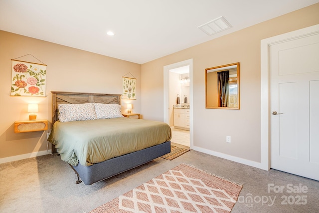 carpeted bedroom with visible vents, baseboards, and ensuite bathroom