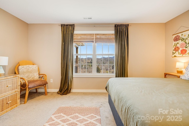 bedroom featuring baseboards, visible vents, and light colored carpet