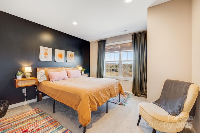 carpeted bedroom featuring baseboards, an accent wall, visible vents, and recessed lighting