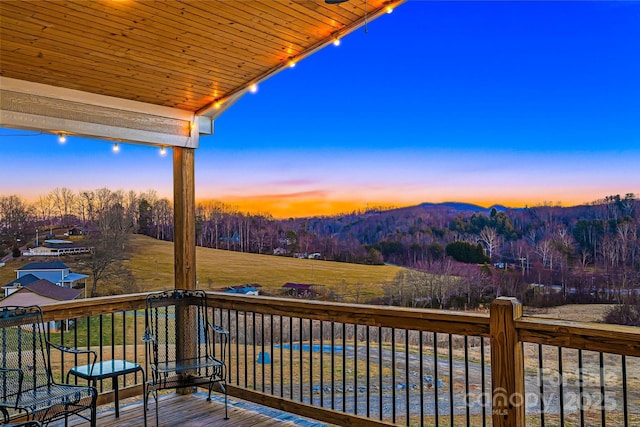 deck with a forest view and a mountain view