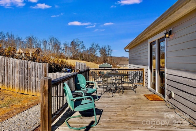 wooden deck featuring outdoor dining space and fence