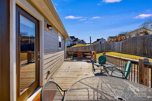 deck with a fenced backyard, a residential view, and outdoor dining area