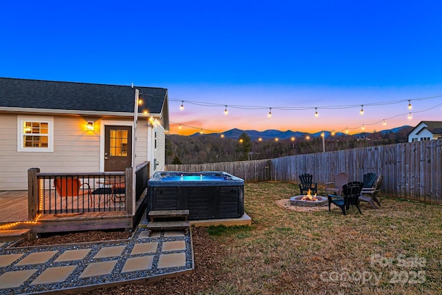 view of yard with a fire pit, a deck with mountain view, a fenced backyard, and central air condition unit