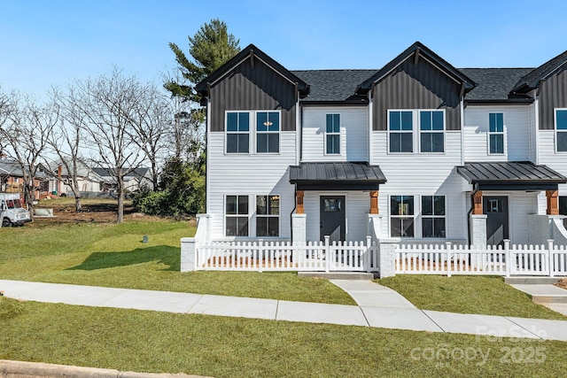 view of front of property featuring board and batten siding, a standing seam roof, and a fenced front yard