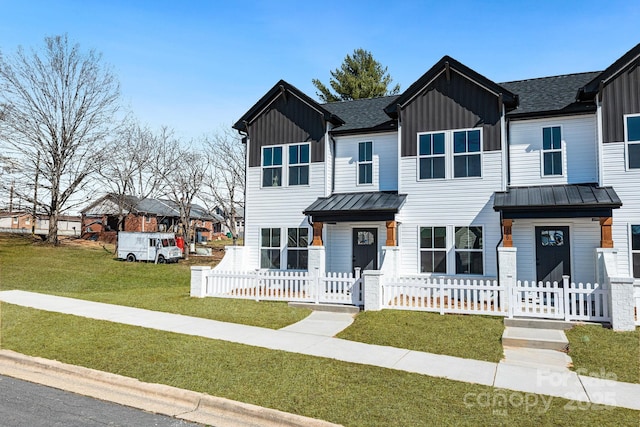 view of front of property featuring a standing seam roof, board and batten siding, a residential view, and a fenced front yard