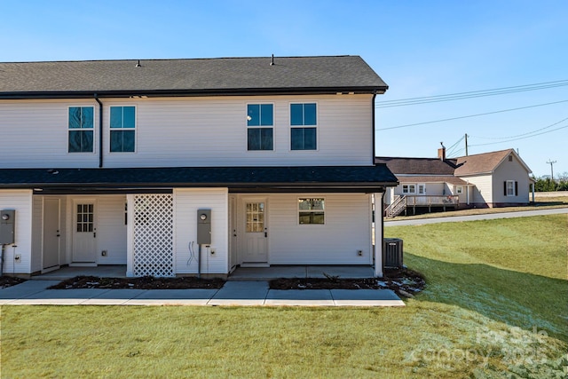 view of front of home with a front yard and central air condition unit