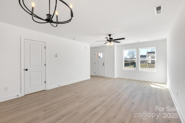 unfurnished living room featuring light wood finished floors, baseboards, visible vents, and ceiling fan with notable chandelier