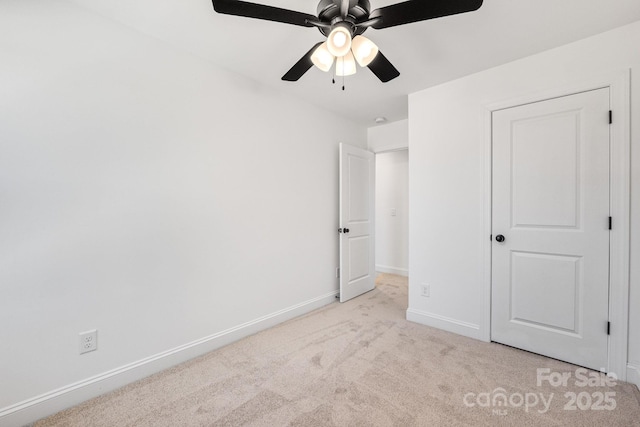 unfurnished bedroom featuring light carpet, ceiling fan, and baseboards