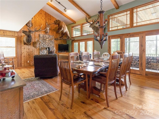 167 Bold Springs Rd, Sylva, NC 28779 - dining area featuring beamed ceiling, high vaulted ceiling, a chandelier, wood finished floors, and wooden walls