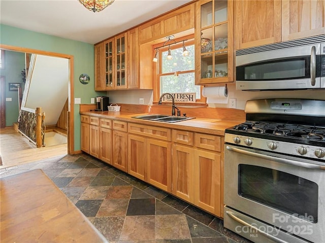 167 Bold Springs Rd, Sylva, NC 28779 - kitchen with glass insert cabinets, butcher block counters, appliances with stainless steel finishes, a sink, and stone tile flooring