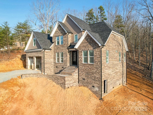 view of front of property featuring a garage, brick siding, a shingled roof, driveway, and crawl space