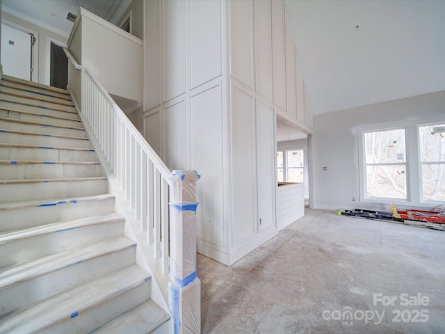 stairs featuring high vaulted ceiling