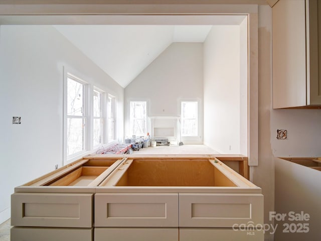 kitchen featuring lofted ceiling and cream cabinets