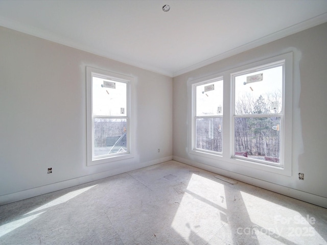 spare room featuring ornamental molding and baseboards