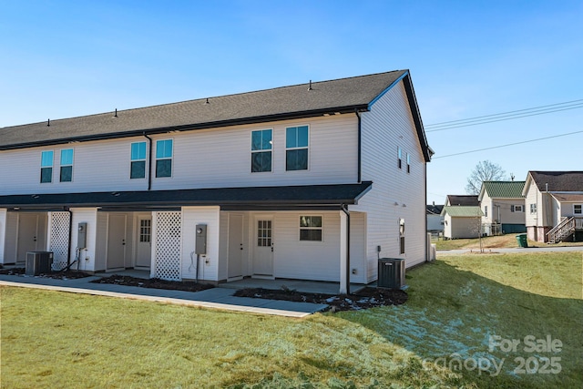 view of front of house featuring a front lawn, a patio area, and cooling unit