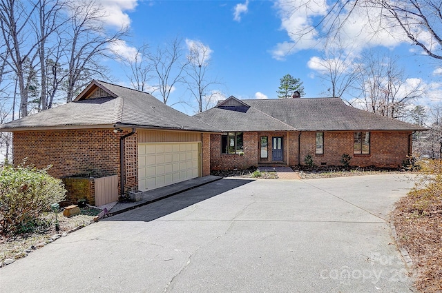 single story home featuring driveway, roof with shingles, a garage, and brick siding