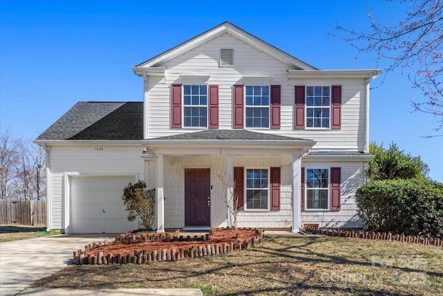 traditional-style house with a garage, a front yard, driveway, and a shingled roof