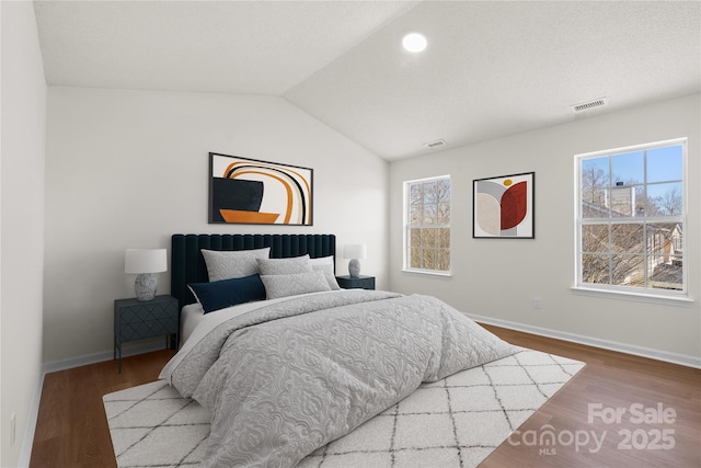 bedroom featuring lofted ceiling, light wood-style floors, multiple windows, and visible vents