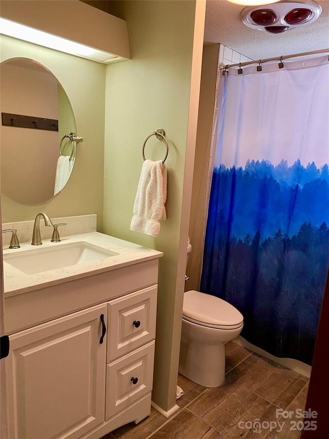 full bath with vanity, wood finished floors, a textured ceiling, curtained shower, and toilet