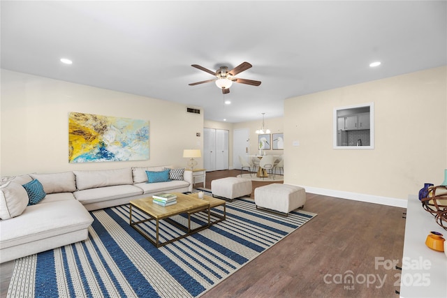 living area featuring ceiling fan with notable chandelier, recessed lighting, wood finished floors, and baseboards