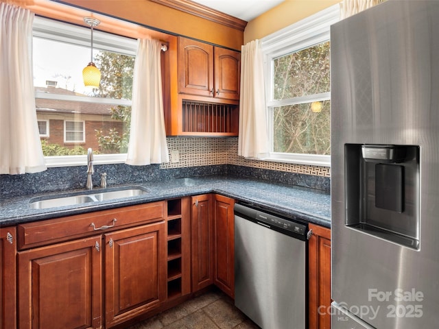 kitchen featuring a wealth of natural light, appliances with stainless steel finishes, brown cabinets, and a sink