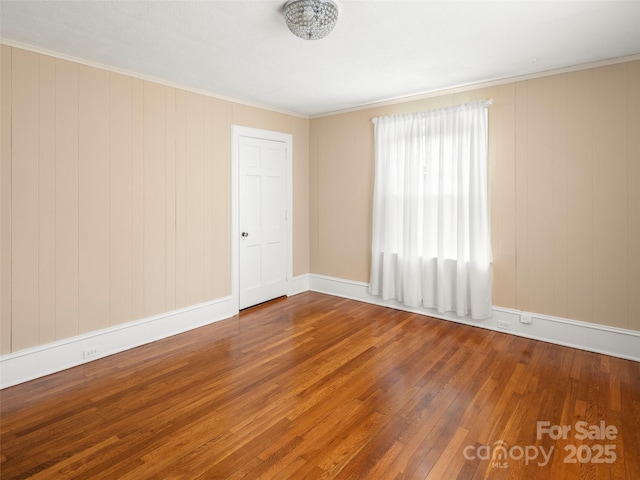 empty room featuring wood finished floors and baseboards