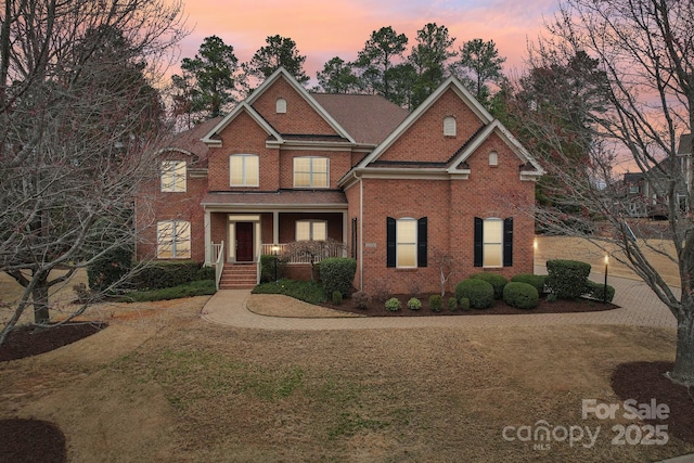 traditional-style house featuring brick siding and a porch