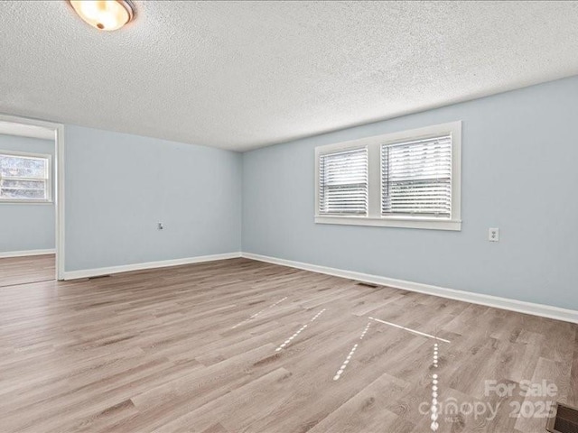 spare room featuring baseboards and wood finished floors