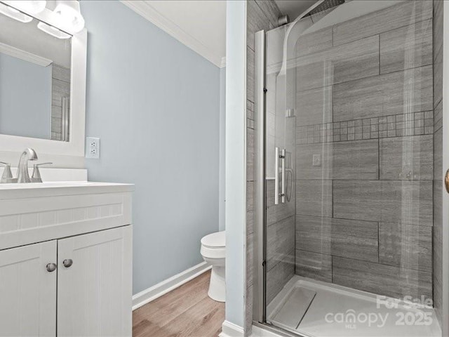 full bath with a stall shower, vanity, toilet, and crown molding