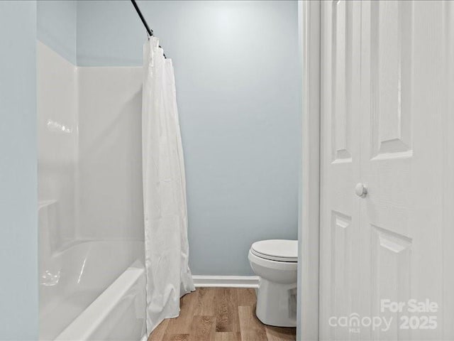 full bathroom with toilet, baseboards, wood finished floors, and shower / tub combo with curtain