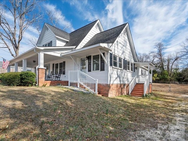 view of front facade featuring covered porch and a front yard