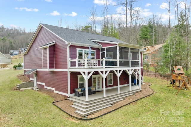 back of house with a lawn, french doors, a wooden deck, and a sunroom