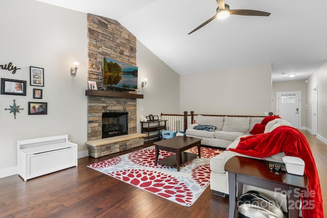 living area featuring baseboards, wood finished floors, a fireplace, and vaulted ceiling