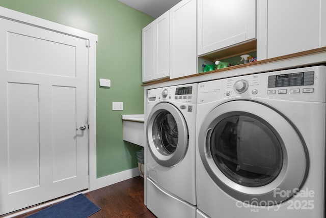 laundry area featuring baseboards, cabinet space, separate washer and dryer, and dark wood-type flooring