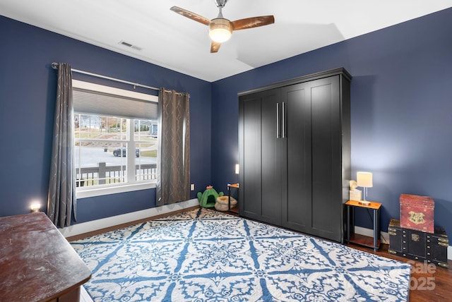 bedroom featuring a ceiling fan, visible vents, baseboards, and a closet