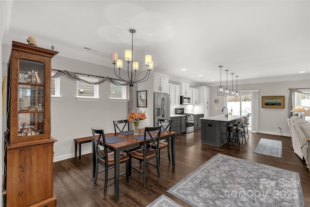 dining space with dark wood-style floors, a chandelier, crown molding, and baseboards