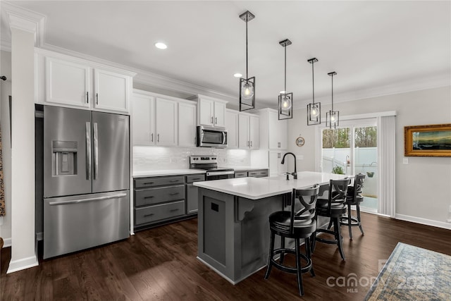 kitchen featuring stainless steel appliances, light countertops, crown molding, and backsplash