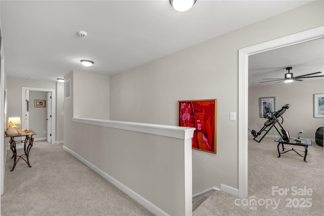 hall featuring carpet floors, an upstairs landing, and baseboards