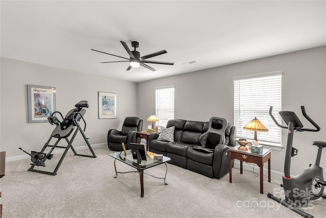 living area with a ceiling fan, carpet, and baseboards